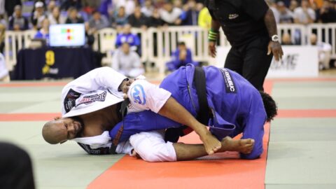 A brazilian jiu jitsu practitioner attacking a leg lock in competition