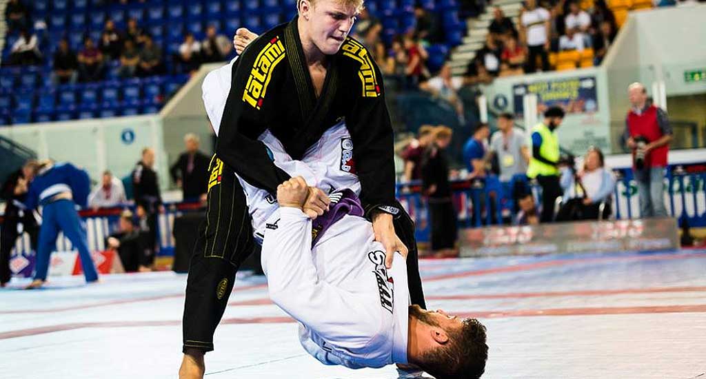 A competitor works to pass the guard in a Brazilian Jiu Jitsu competition