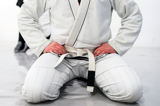 Beginner Brazilian jiu jitsu student wearing a white belt during class