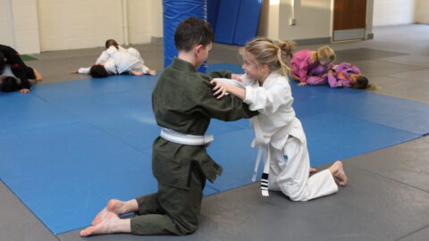 Kids Brazilian Jiu Jitsu students preparing to spar from their knees during a BJJ class at Spartan MMA