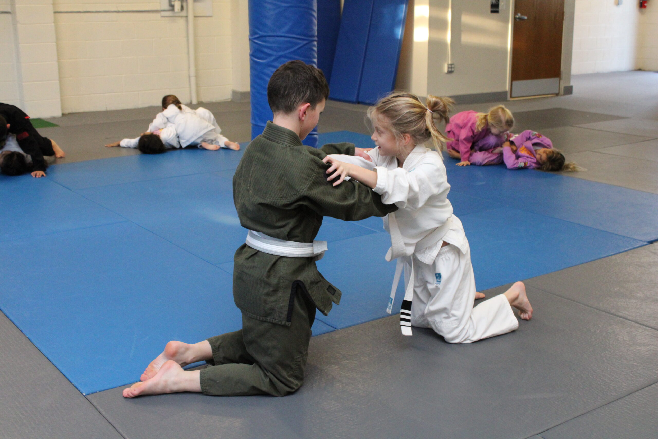 Kids Brazilian Jiu Jitsu students preparing to spar from their knees during a BJJ class at Spartan MMA