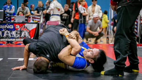 No Gi Brazilian Jiu Jitsu competitor applying a kimura submission during grappling competition