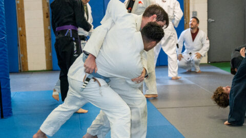 New Brazilian Jiu-Jitsu students practicing fundamental techniques during a beginner class.