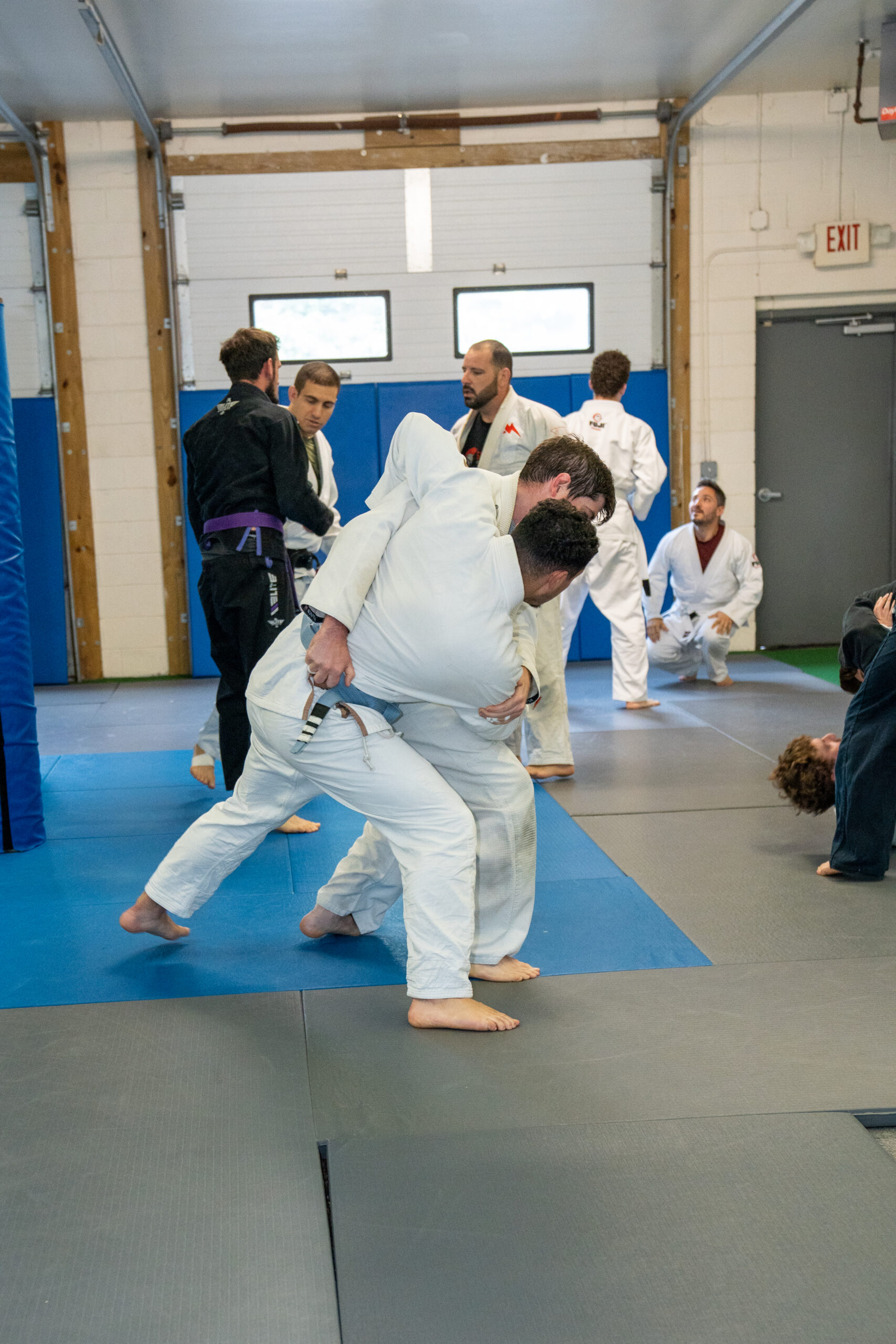 New Brazilian Jiu-Jitsu students practicing fundamental techniques during a beginner class.