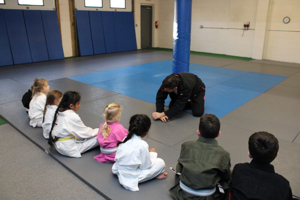 Brazilian Jiu-Jitsu instructor teaching kids during class in Ocean Township NJ