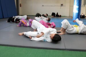 Kids practicing shrimping during a Brazilian Jiu-Jitsu warm-up at Spartan Mixed Martial Arts in Ocean Township NJ